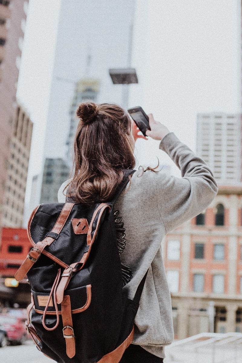 Woman takes photo with bag