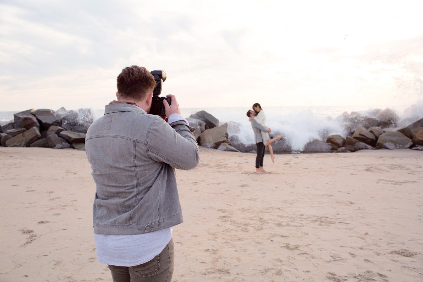 Photographer at beach with wedding couple