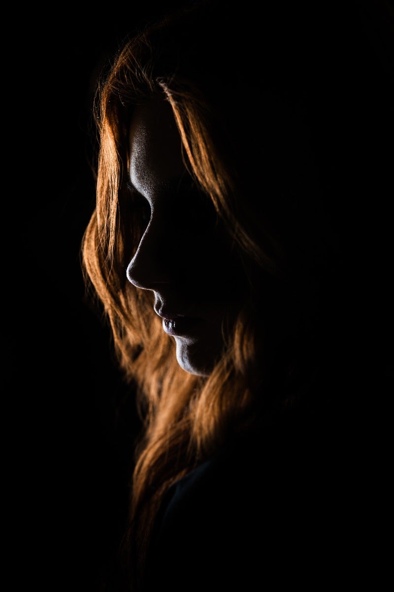 Dark portrait of woman with red hair