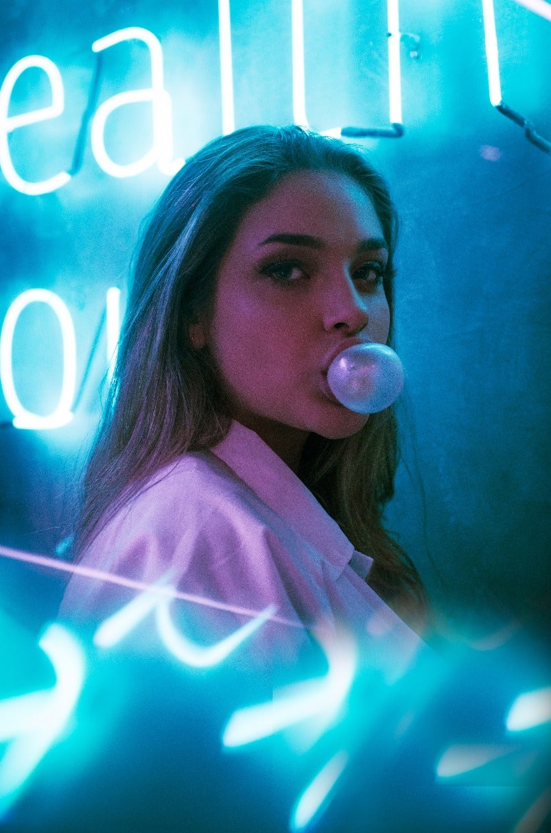 Women chewing gum with neon lights