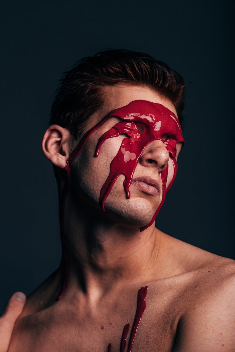 Portrait of man with red paint on face